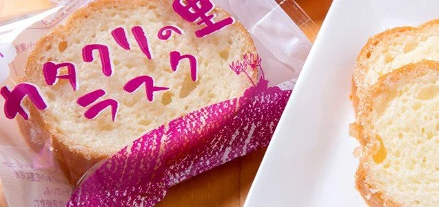 砂糖をまとったカタクリの里ラスクを木の皿に盛った写真